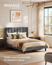 Slate grey wingback double bed in a sunlit bedroom with a robot vacuum beside the frame