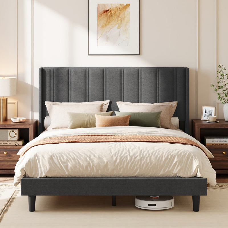 Slate grey upholstered king size bed with wingback headboard in a styled bedroom