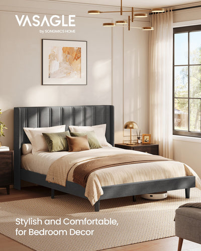 Vasagle slate grey wingback bed dressed with cushions beside a bedside lamp