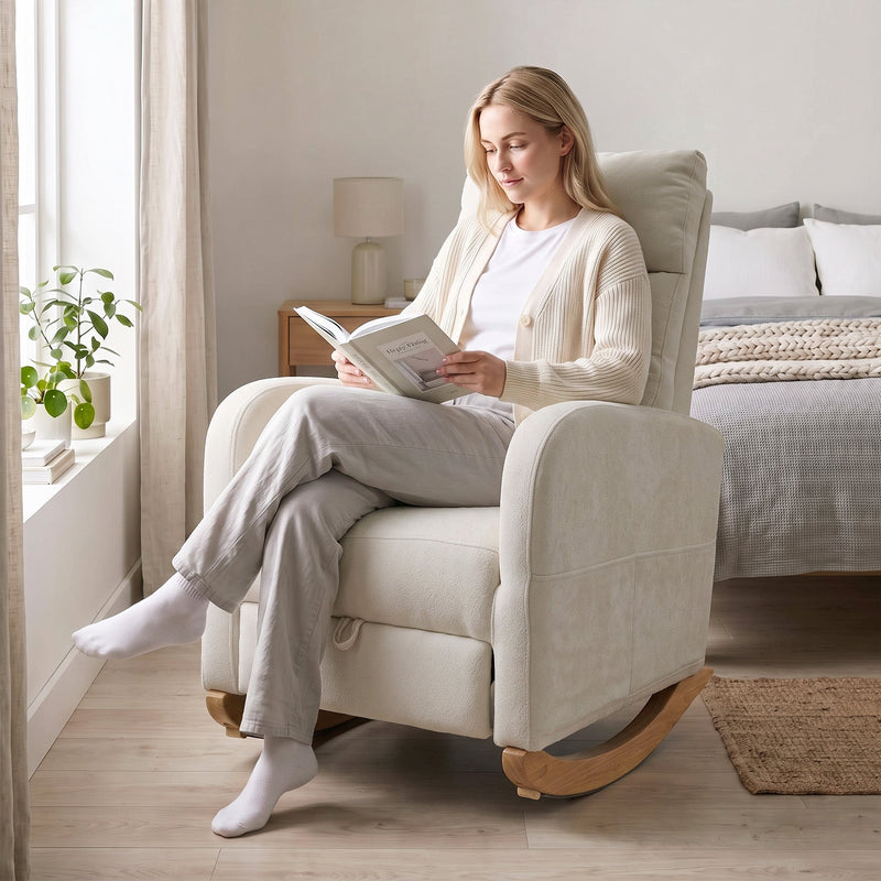 Woman reading in the cream white rocking chair beside a bed