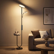 HOMCOM black uplighter floor lamp lit beside an armchair in a living room