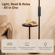 Floor lamp side table holding a book, glasses and drink beside a sofa