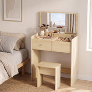 Oak vanity desk with makeup brushes and stool beside a bed