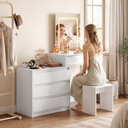 Person sitting at the vanity desk using the LED mirror to get ready