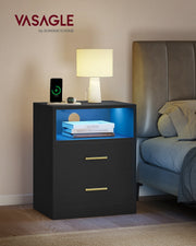 Vasagle Ink Black bedside table styled beside a bed with a lamp and phone charging on top