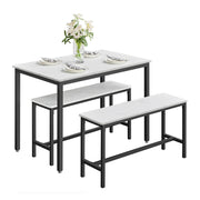 Dining table and 2 benches set with plates and a vase of flowers on the table top, shown on a plain background