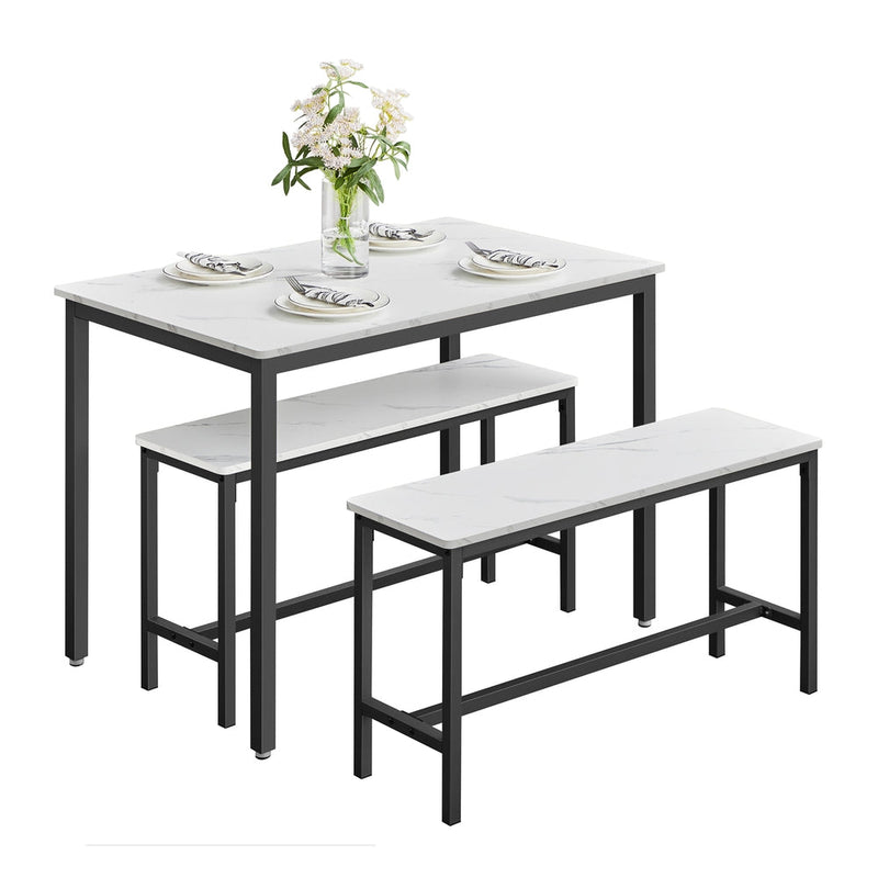 Dining table and 2 benches set with plates and a vase of flowers on the table top, shown on a plain background