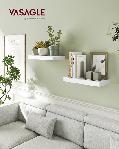 White floating wall shelves mounted above a grey sofa in a living room