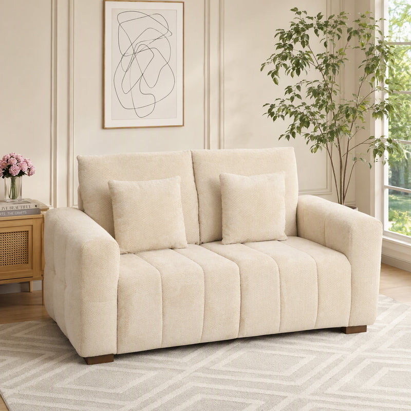 Cream white 2 seater velvet sofa in a living room with a plant and framed art