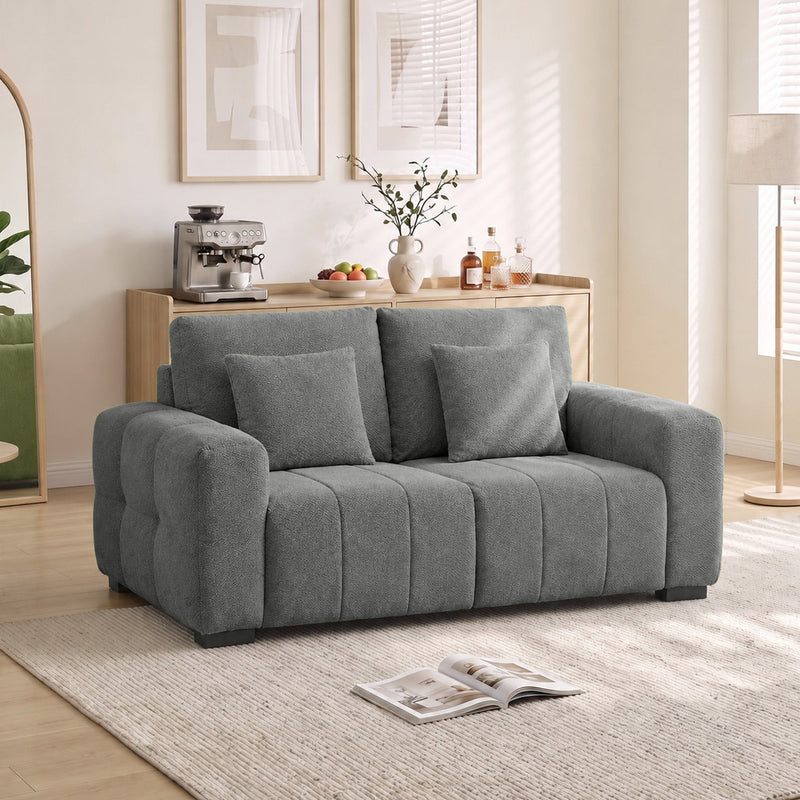 Grey 2 seater velvet sofa in a bright living room beside a sideboard and floor lamp