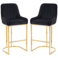 Set of 2 black velvet bar stools with gold legs on a white background
