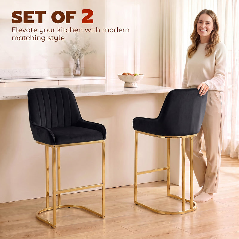 Woman standing beside two black velvet bar stools at a kitchen island