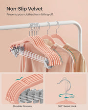 Row of light pink velvet hangers with shoulder grooves and 360 degree swivel hooks