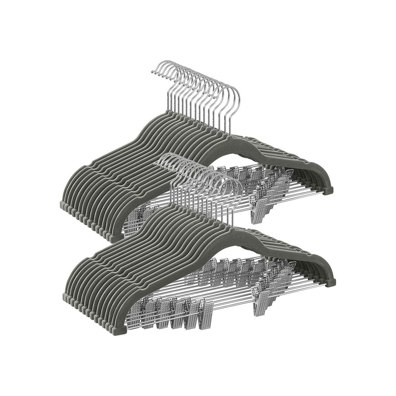 Stacked grey velvet trouser hangers with metal clips and chrome hooks