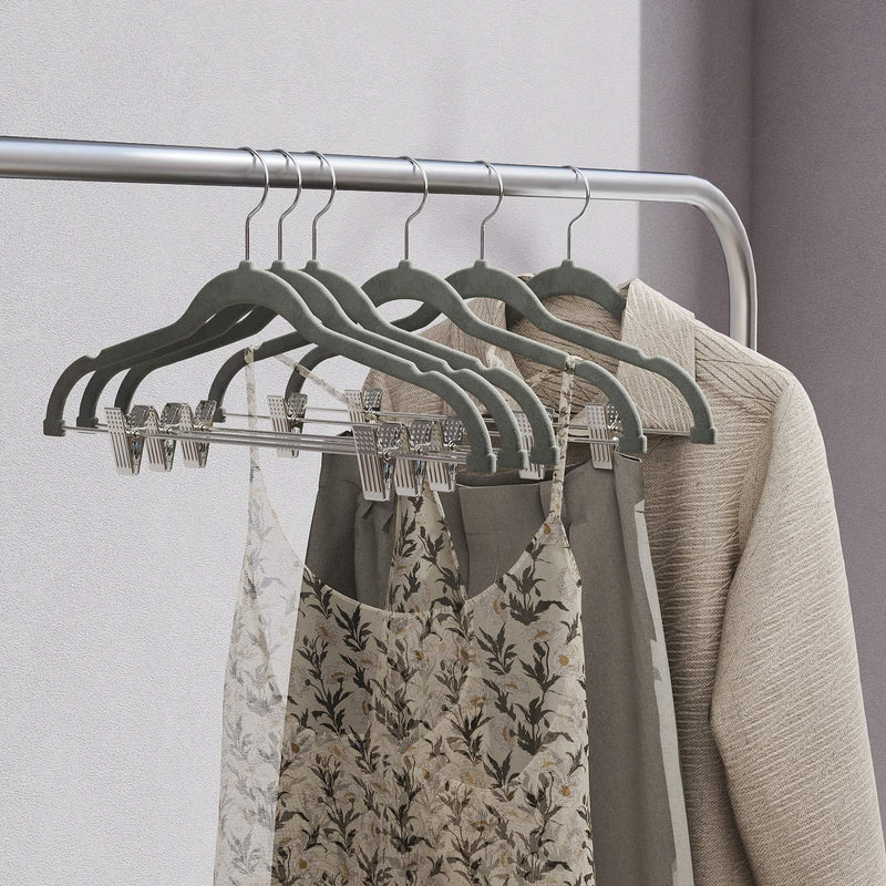 Grey velvet hangers holding dresses and lace clothing on a rail