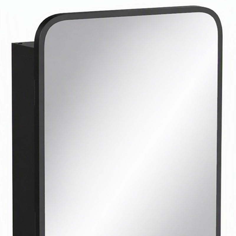 Close-up of the rounded black mirror frame and cabinet side