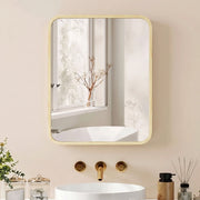 Natural wood frame mirror cabinet above a white basin with gold taps