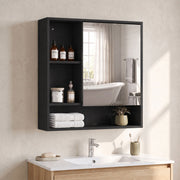 Black mirror cabinet with bottles and folded towels on the wall of a bathroom with a freestanding bath