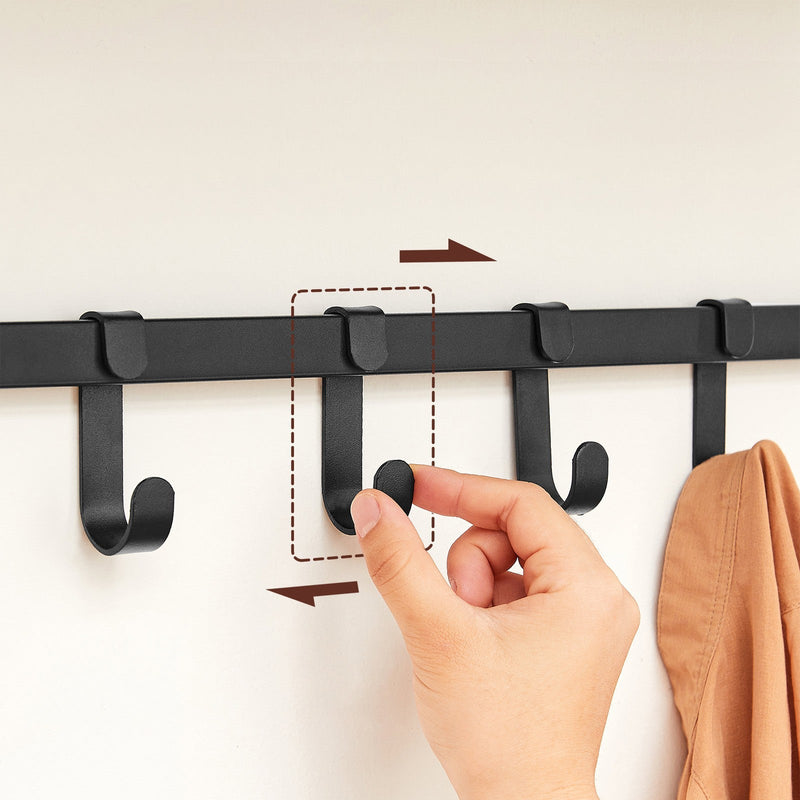 A hand sliding one of the removable hooks along the black metal bar