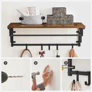 Coat rack on a white wall with a basket and boxes above a three-step mounting guide