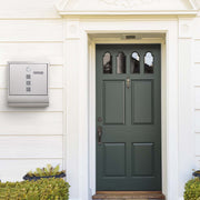 SONGMICS wall-mounted mailbox mounted on a wall beside a green front door