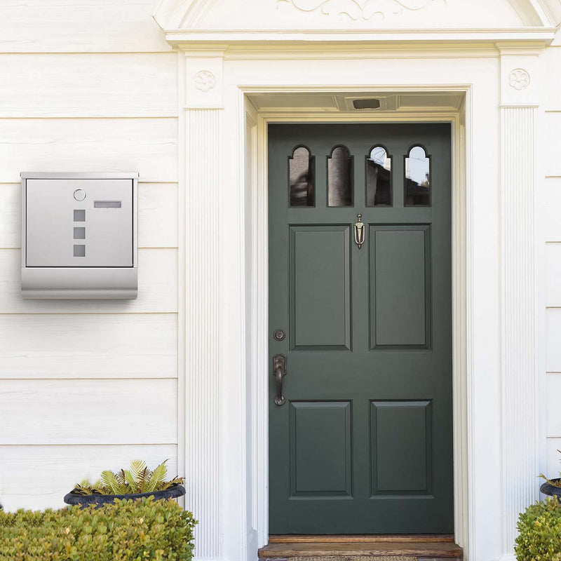 SONGMICS wall-mounted mailbox mounted on a wall beside a green front door