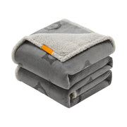 Grey dog blanket folded in a stack showing the patterned flannel face and cream sherpa lining