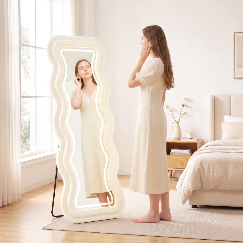 Woman using the wavy mirror in a bedroom styled with a nightstand and bed