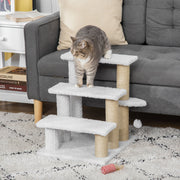 Tabby cat stepping down the white cat stairs beside a grey sofa