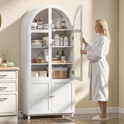 Woman in a robe opening the cabinet door to towels and toiletries on the shelves