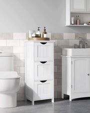 White 3 drawer cabinet standing between a toilet and a basin in a tiled bathroom