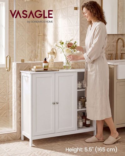Woman in a robe arranging flowers on the white Vasagle bathroom cabinet