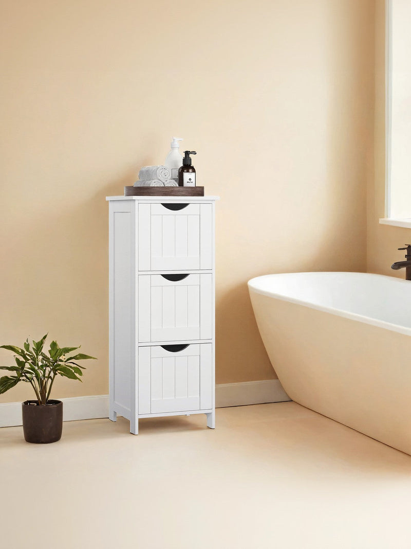 White bathroom cabinet styled next to a freestanding bathtub with a potted plant