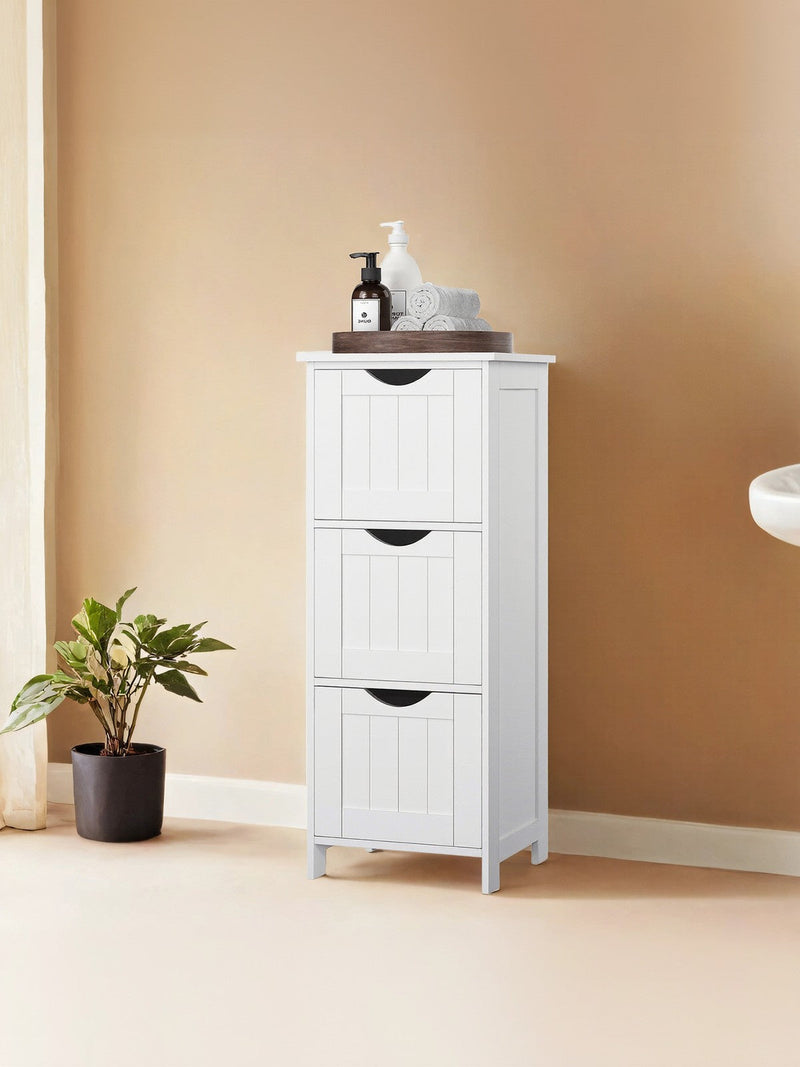 White bathroom cabinet styled beside a sink with a wash bag on top