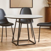 Round marble effect dining table set for four in an open-plan dining area