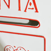 Close-up of the letter slot edge and red embossed lettering on the white postbox