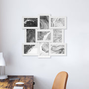White collage picture frame with black and white marble artwork above a home office desk
