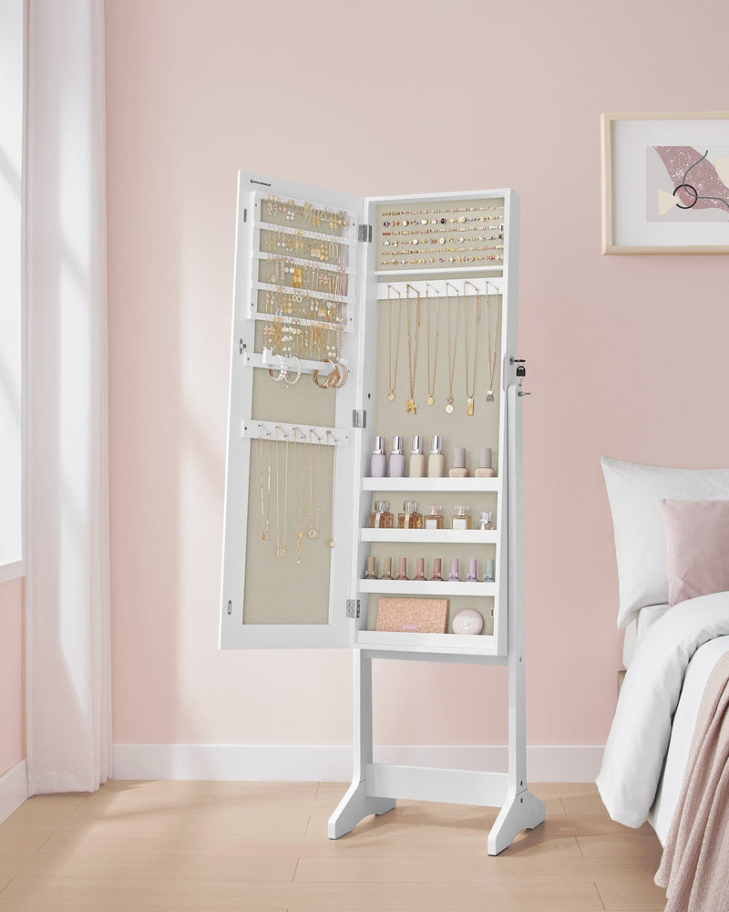 Open jewellery cabinet standing beside a bed in a pink bedroom