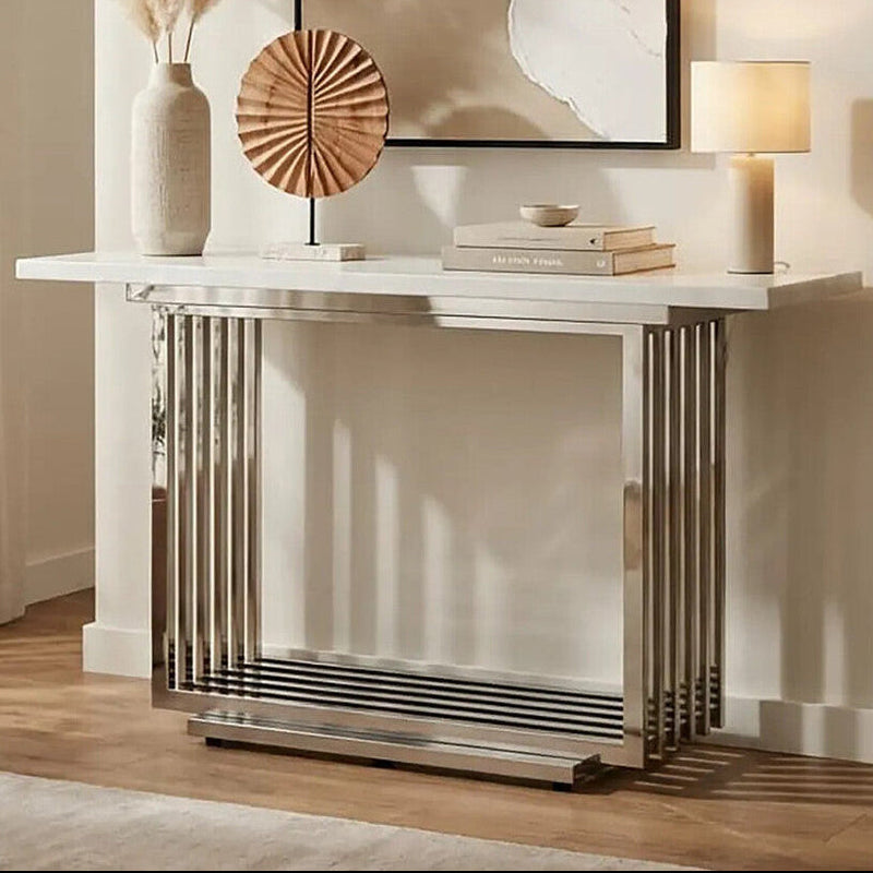 White marble effect console table with silver geometric steel base in a styled room setting