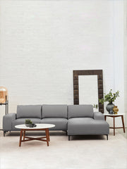 Acacia-legged marble coffee table beside a low sofa in a minimalist room