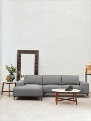 Marble coffee table in a living room with a jute rug and houseplants
