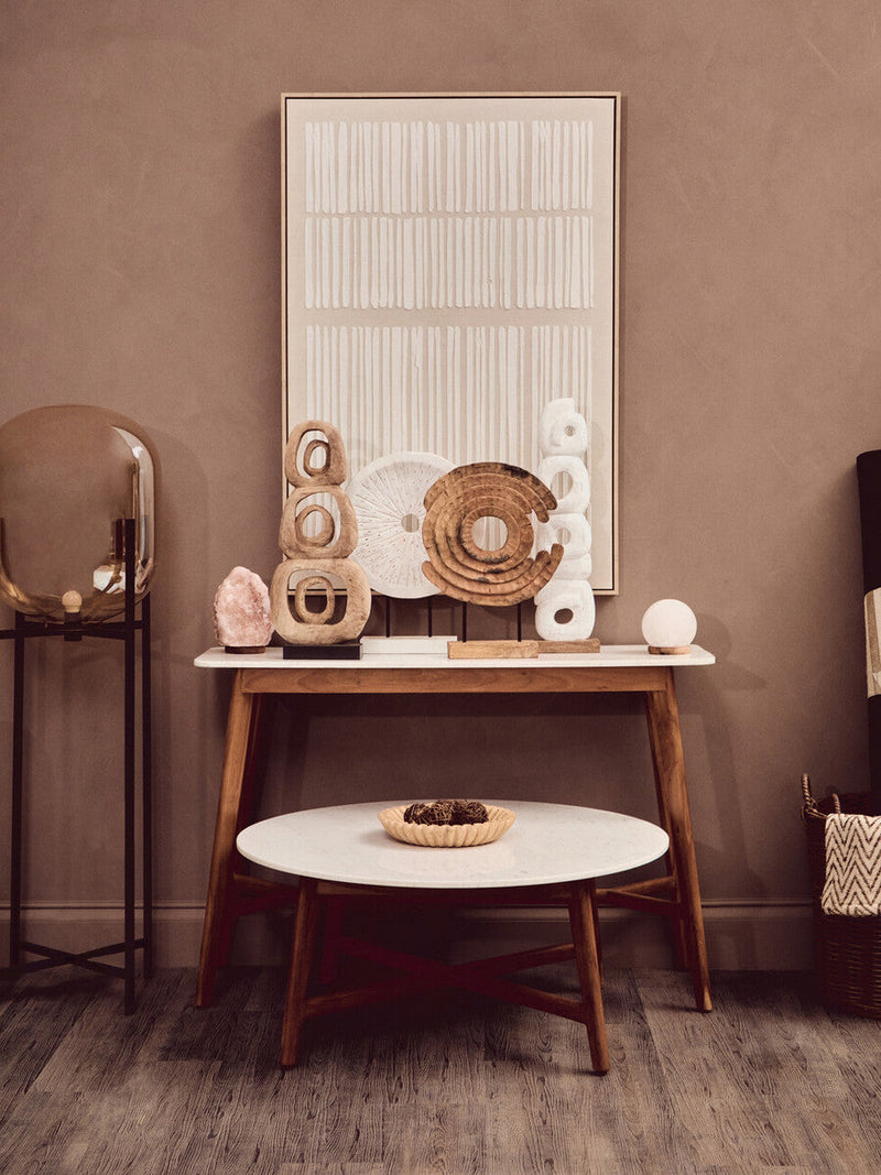 Round marble coffee table styled with a low bowl and stacked books
