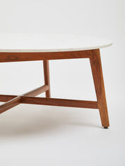 Low-angle room view of the marble coffee table and its acacia legs