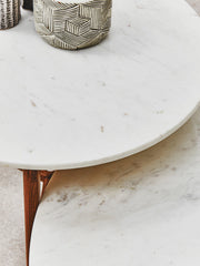 White marble coffee table with acacia wood legs in a bright sitting room