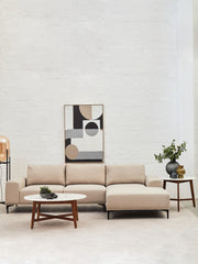 Round marble coffee table styled with books and a candle in a modern lounge
