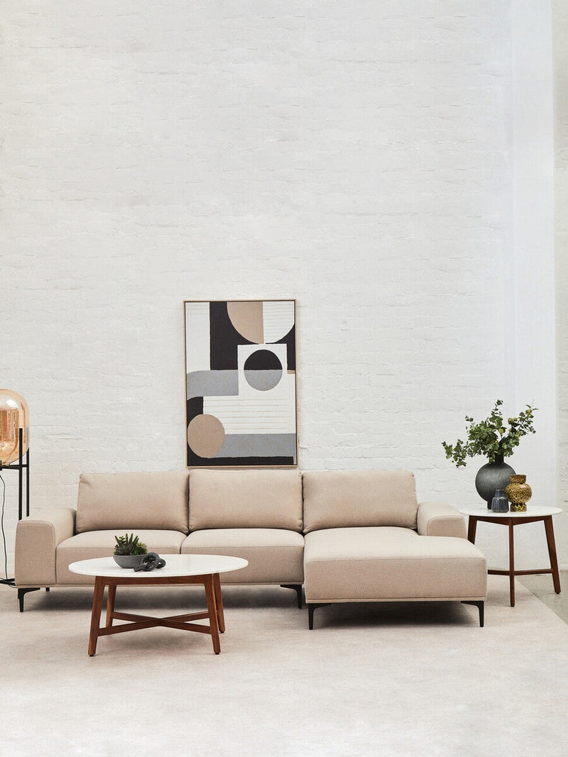 Round marble coffee table styled with books and a candle in a modern lounge