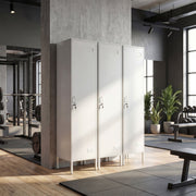 Row of three white lockers in a gym