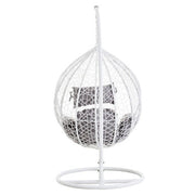 Angled view of the white rattan hanging chair, plain background