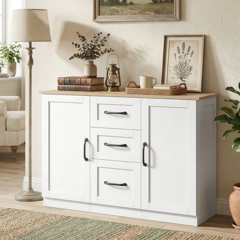 White sideboard in a living room styled with a lamp, framed prints and a lantern on top