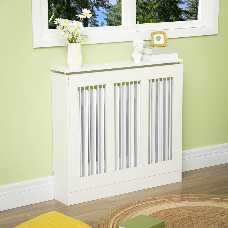 White radiator cover below a window with flowers and decor on the top shelf